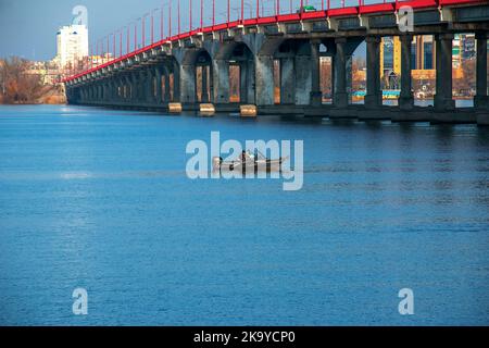 Dnjepr, Dnepropetrovsk, Ukraine - 11.13.2021: Fischer auf einem Boot auf dem Fluss fangen im Herbst Fisch. Angeln ist eine besondere Art von Sport. Stockfoto