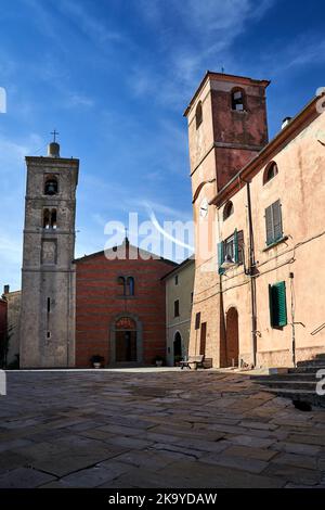 Gepflasterter Platz mit steinernen Glockentürmen und historischer Kirche in Montiano, Italia Stockfoto