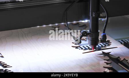 Die Lasermaschine schneidet ein Bild auf einem flachen Holzblech aus Sperrholz oder Stahl in einer Universität Stockfoto