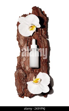 Weiße Glas-Kosmetikflasche auf strukturiertem Baumrindenpodium mit weißen Orchideenblumen in Sonnenstrahlen mit harten Schatten. Demonstration von kosmetischen Produkten mit Kopierplatz in flacher Lay-Ausführung. Stockfoto