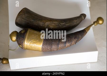 Ausstellung eines alten Pulverhorns auf weißem Hintergrund, Nahaufnahme. Stockfoto