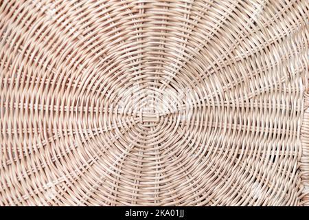 Kreisförmige Webart Rattan-Muster, runde Rattan Möbel Hintergrund hellbraune Textur, Webart Rattan Textur und Hintergrund. Ein Fragment eines Korbes aus Weidenzweigen oder Gartenmöbel, Textur Stockfoto