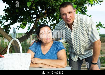 Porträt eines positiven Mannes und seiner älteren Mutter im Garten Stockfoto