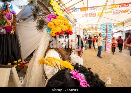 Morelia, Mexiko, 30. Oktober 2022, Tag der Toten zu den Feierlichkeiten in Michoacan gehört das Catrina Festival in Capula, einem Dorf, das für seine Tonskulpturen bekannt ist, wo dieses Live-Modell für Passanten posiert. Die elegant gekleideten Skelette oder Schädel, bekannt als Catrinas, wurden während der mexikanischen Revolution Anfang des 20. Jahrhunderts als Satire der moralisch dekadenten Oberschicht populär. Brian Overcast/Alamy Live News Stockfoto
