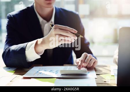 Ein männlicher Geschäftsmann nimmt an der Sitzung Teil und analysiert die Jahresabschlüsse und Investitionen bei der Sitzung Stockfoto