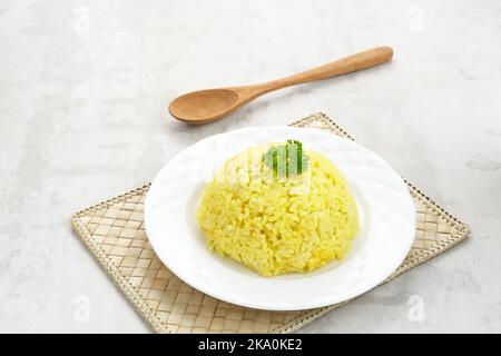 Nasi Kuning, traditionelles indonesisches Essen aus Reis, zubereitet mit Kurkuma und Kokosmilch und Gewürzen, serviert mit verschiedenen Beilagen Stockfoto