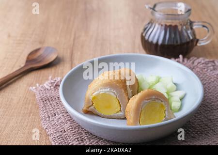 Pempek Palembang, traditionelles Essen aus Süd-Sumatra, Indonesien. Dieses Fischfutter ist sehr beliebt. Serviert mit Cuko-Sauce und Gurkenscheiben. Stockfoto