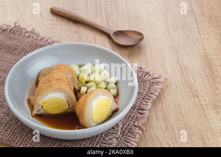 Pempek Palembang, traditionelles Essen aus Süd-Sumatra, Indonesien. Dieses Fischfutter ist sehr beliebt. Serviert mit Cuko-Sauce und Gurkenscheiben. Stockfoto