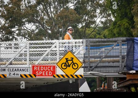 Brisbane, Queensland, Australien - 2022. August: Ein Industriearbeiter überquert eine Brücke am Brisbane River. Stockfoto