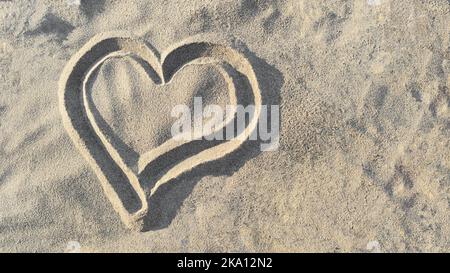 Herz gezeichnet auf Sand, Draufsicht. Konzept von Liebe und Gesundheit, Draufsicht. Speicherplatz kopieren. Stockfoto