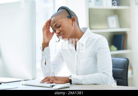 Schwarze Frau, Kopfschmerzen und Stress im Callcenter durch Computer für die Beratung im Kundenservice im Büro. Afroamerikanische Frau leidet unter Stockfoto