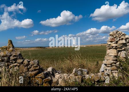 Blick auf den Leuchtturm von Nash Point, eingerahmt von einer alten Mauer und Bauernhöfen Stockfoto