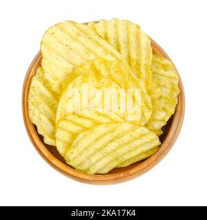 Wasabi und Nori aromatisiert, gesalzene Rüschen, zerzauste Kartoffelchips, in einer Holzschüssel. Zerklitterte Kartoffeln, frittiert. Stockfoto