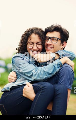 Ich habe Glück, dass ich meine Liebe so jung gefunden habe. Ein Teenager, der seine Teenager-Freundin im Freien trägt. Stockfoto