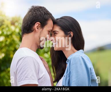 Ein liebevolles junges Paar, das sich umarmt, während es draußen steht. Stockfoto