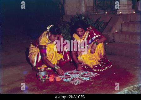 Während Diwali tragen die Menschen ihre schönsten Kleider, beleuchten das Innere und Äußere ihrer Häuser mit Saaki (irdenen Lampe), Diyas und Rangoli, führen Gottesdienste von Lakshmi, der Göttin des Wohlstands und des Reichtums, Lichtfeuerwerk und nehmen an Familienfesten Teil, wo Mithai (Süßigkeiten) und Geschenke geteilt werden. Stockfoto