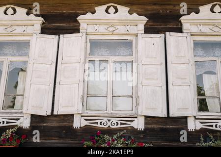 Ein einfaches weißes Fenster mit Fensterläden in einem Landhaus Stockfoto