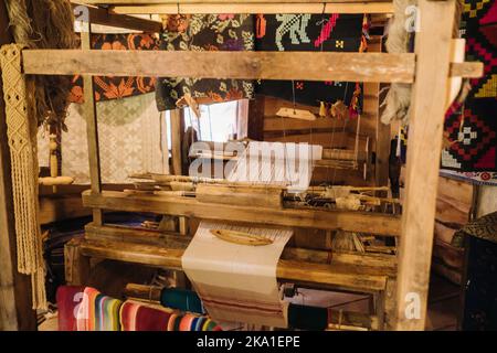 Ein Webstuhl in einem alten Holzhaus, das im 19.. Jahrhundert gebaut wurde Stockfoto