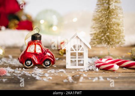 Weihnachts-Spielzeugauto und Details der Weihnachtsdekor auf einem unscharfen Hintergrund. Stockfoto