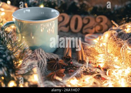 Weihnachtliche Komposition mit einer Tasse Tee, Gewürzen auf einem Strickelement. Stockfoto