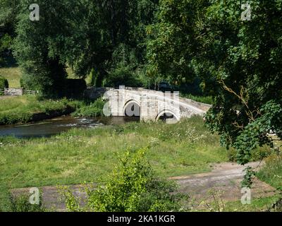 Alte Steinbrücke über den Fluss Wye, die nach Haddon Hall, Bakewell, Derbyshire, Großbritannien führt Stockfoto