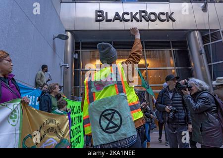 Eine Aussterbungsrebellion Klimaaktivisten erheben ihre Faust aus Protest vor dem Hauptquartier des Finanzinvestitionsunternehmens BlackRock während eines Protestes der „Occupy Park Avenue“ in New York City. Dutzende Klimaaktivisten mit einem großen Banner mit der Aufschrift „Occupy Park Avenue“ und Plakaten, die die fossile Energiewirtschaft anvisierten, marschierten entlang der Park Ave vom neuen Hauptsitz der JPMorgan Chase Bank zum Hauptsitz des Finanzinvestitionsunternehmens BlackRock, um gegen die Investitionen dieser Unternehmen in fossile Energieträger zu protestieren. Sie fordern Klimamaßnahmen und die Regierung Kathy Hochul dazu auf, eine Steuer auf die Reichen zu erheben und zu skandieren Stockfoto