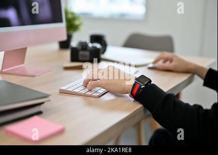 Nahaufnahme, Geschäftsmann oder Büroangestellter, der Computer benutzt, auf der pc-Tastatur tippt und an seinem Schreibtisch arbeitet. Stockfoto