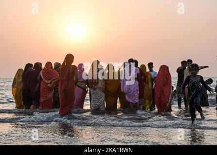 Mumbai, Indien. 30. Oktober 2022. Hinduistische Frauen stehen im Wasser, um anlässlich des Chhath Puja in Mumbai zur untergehenden Sonne am Strand von Juhu zu beten. Eifrige Anhänger, besonders aus den nördlichen Staaten Indiens, beten zum sonnengott (untergehende und aufgehende Sonne), der ihm dafür dankt, dass er das Leben auf der Erde geschenkt hat. Eifrige Anhänger tauchen in die Gewässer und halten sich bei dieser Gelegenheit schnell. Kredit: SOPA Images Limited/Alamy Live Nachrichten Stockfoto