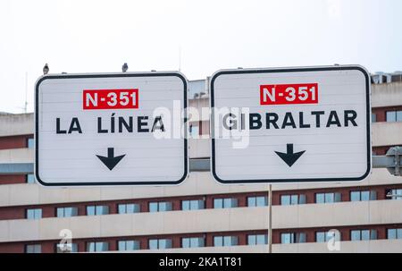 Straßenschilder auf zweispuriger Fahrbahn mit Richtungspfeilen für Routen nach Gibraltar und La Linea in Spanien. Stockfoto
