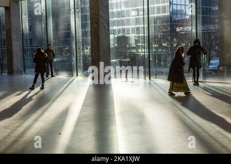 Die niedrige Wintersonne erhellt die Bahnhofskonbahn des Gare du Nord in Brüssel. Passanten. Stockfoto