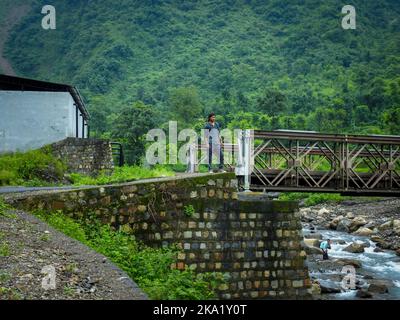 August 22. 2018. Dehradun City Indien. Ein Alleinreisender, der auf einer kleinen Brücke über den Fluss Kali Gad steht, der ein Nebenfluss des Song River am berühmten Fluss ist Stockfoto