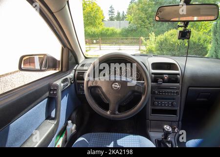 Silberblau 2002 Opel Vauxhall Astra geparkt vor der Hausgarage an sonnigen Tag Innenraum Stockfoto