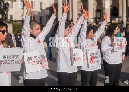 Kleinere iranische Proteste dauern bis zum Wochenende in ganz London an, wobei eine Handvoll auf dem Trafalgar Square mit gefälschtem Blut bedeckt ist und viele durch Lo fahren Stockfoto