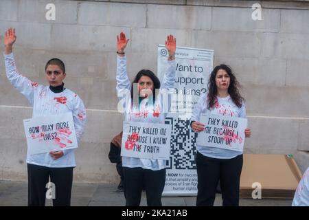 Kleinere iranische Proteste dauern bis zum Wochenende in ganz London an, wobei eine Handvoll auf dem Trafalgar Square mit gefälschtem Blut bedeckt ist und viele durch Lo fahren Stockfoto