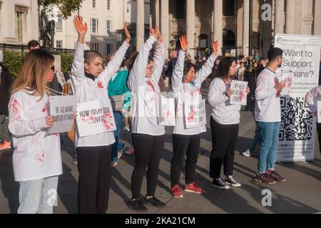 Kleinere iranische Proteste dauern bis zum Wochenende in ganz London an, wobei eine Handvoll auf dem Trafalgar Square mit gefälschtem Blut bedeckt ist und viele durch Lo fahren Stockfoto