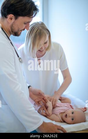 Chirurg überprüft die Gliedmaßen von Babys und bewegt sie Stockfoto