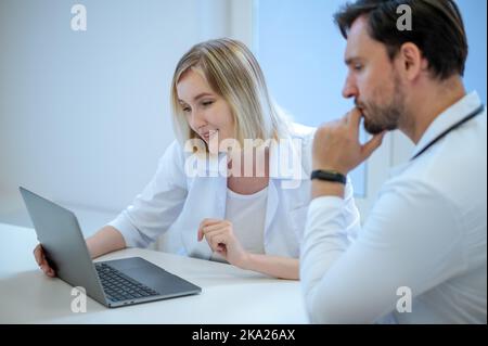 Zwei Ärzte sitzen dicht und diskutieren etwas Stockfoto