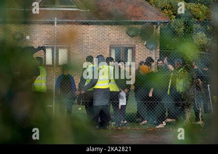 Eine Ansicht der Menschen, die als Migranten in der Manston-Einwanderungsanstalt für kurzfristige Zuwanderungen im ehemaligen Defense Fire Training and Development Center in Thanet, Kent, gedacht wurden. 700 Personen wurden aus Sicherheitsgründen in die Manston-Einrichtung gebracht, nachdem am Sonntag Brandanzündvorrichtungen auf ein Migrantenzentrum der Grenztruppen in Dover geworfen wurden. Bilddatum: Montag, 31. Oktober 2022. Stockfoto