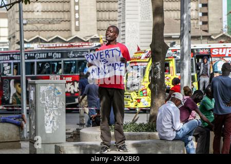 Nairobi, Kenia. 25. Oktober 2022. Julius Kamau, ein lautstarker kenianischer Menschenrechtsaktivist, spricht während er ein Plakat mit der Aufschrift ‘Armut ist menschengemacht' auf den Straßen des Nairobi Central Business District hält. Julius wurde während seiner Proteste gegen Armut und Ungerechtigkeit in Kenia mehrmals von der Polizei verhaftet und schikaniert. Trotz der Verfassung, die das Recht garantiert, zu protestieren und Petitionen an öffentliche Behörden zu stellen, hat die Polizei in zahlreichen Fällen Proteste mit brutaler Gewalt gebrochen und Protestierenden gesetzwidrig verhaftet. Kredit: SOPA Images Limited/Alamy Live Nachrichten Stockfoto