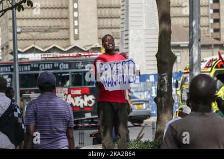 Nairobi, Kenia. 25. Oktober 2022. Julius Kamau, ein lautstarker kenianischer Menschenrechtsaktivist, spricht während er ein Plakat mit der Aufschrift ‘Armut ist menschengemacht' auf den Straßen des Nairobi Central Business District hält. Julius wurde während seiner Proteste gegen Armut und Ungerechtigkeit in Kenia mehrmals von der Polizei verhaftet und schikaniert. Trotz der Verfassung, die das Recht garantiert, zu protestieren und Petitionen an öffentliche Behörden zu stellen, hat die Polizei in zahlreichen Fällen Proteste mit brutaler Gewalt gebrochen und Protestierenden gesetzwidrig verhaftet. Kredit: SOPA Images Limited/Alamy Live Nachrichten Stockfoto