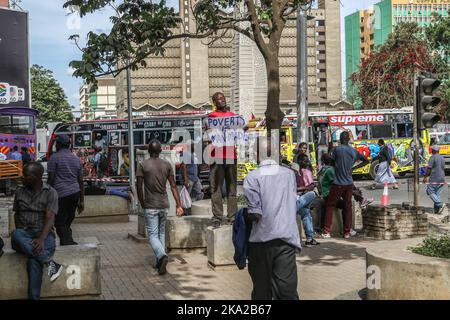 Nairobi, Kenia. 25. Oktober 2022. Julius Kamau, ein lautstarker kenianischer Menschenrechtsaktivist, spricht während er ein Plakat mit der Aufschrift ‘Armut ist menschengemacht' auf den Straßen des Nairobi Central Business District hält. Julius wurde während seiner Proteste gegen Armut und Ungerechtigkeit in Kenia mehrmals von der Polizei verhaftet und schikaniert. Trotz der Verfassung, die das Recht garantiert, zu protestieren und Petitionen an öffentliche Behörden zu stellen, hat die Polizei in zahlreichen Fällen Proteste mit brutaler Gewalt gebrochen und Protestierenden gesetzwidrig verhaftet. Kredit: SOPA Images Limited/Alamy Live Nachrichten Stockfoto