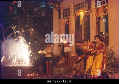 Während Diwali tragen die Menschen ihre schönsten Kleider, beleuchten das Innere und Äußere ihrer Häuser mit Saaki (irdenen Lampe), Diyas und Rangoli, führen Gottesdienste von Lakshmi, der Göttin des Wohlstands und des Reichtums, Lichtfeuerwerk und nehmen an Familienfesten Teil, wo Mithai (Süßigkeiten) und Geschenke geteilt werden. Stockfoto