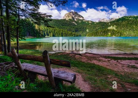 Eine schöne Aufnahme einer Bank vor dem Schwarzen See in Montenegro Stockfoto