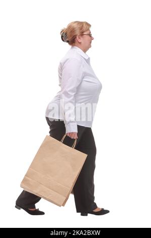 Seitenansicht Porträt einer Frau mittleren Alters, die mit Einkaufstaschen geht Stockfoto