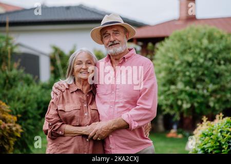 Verliebte ältere Paare posieren gemeinsam in ihrem Garten. Stockfoto