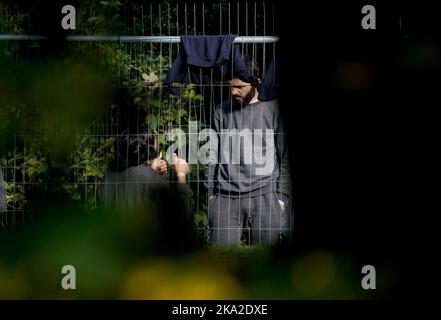 Eine Ansicht der Menschen, die als Migranten in der Manston-Einwanderungsanstalt für kurzfristige Zuwanderungen im ehemaligen Defense Fire Training and Development Center in Thanet, Kent, gedacht wurden. 700 Personen wurden aus Sicherheitsgründen in die Manston-Einrichtung gebracht, nachdem am Sonntag Brandanzündvorrichtungen auf ein Migrantenzentrum der Grenztruppen in Dover geworfen wurden. Bilddatum: Montag, 31. Oktober 2022. Stockfoto