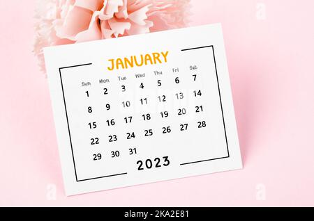 Januar 2023 Monatlicher Tischkalender mit getrockneter Blume auf rosa Hintergrund. Stockfoto