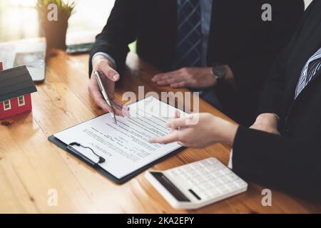 Garantien, Hypotheken, Unterzeichnung, Zinsen auf Darlehen, Immobilienmakler machen Vereinbarungen mit Kunden Häuser und Grundstücke zu kaufen und Vertrag zu unterzeichnen Stockfoto