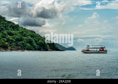 Eine malerische Aussicht auf ein Schiff, das in einem Meer gegen grüne Berge in Puerto Vallarta, Mexiko, segelt Stockfoto