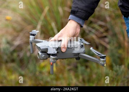 Nahaufnahme der Hand eines Mannes, der das Drohnenfahrzeug hält Stockfoto